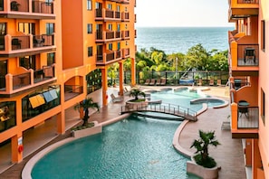 A hotel with a pool area, balconies, and a view of the ocean. - Suite w/ Sea/pool View Luxury Resort Jurere Jbv142 (Florianópolis)