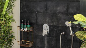 A black shower enclosure with a handheld showerhead and a wall-mounted faucet. - Coastal Garden Villa (Ungasan)