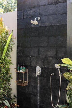 A black shower enclosure with a handheld showerhead and a wall-mounted faucet. - Coastal Garden Villa (Ungasan)
