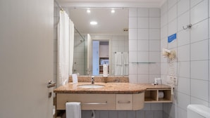 Ein Badezimmer mit Marmorwaschtisch, Spiegel, Handtuchhalter, Fön und Toilette.