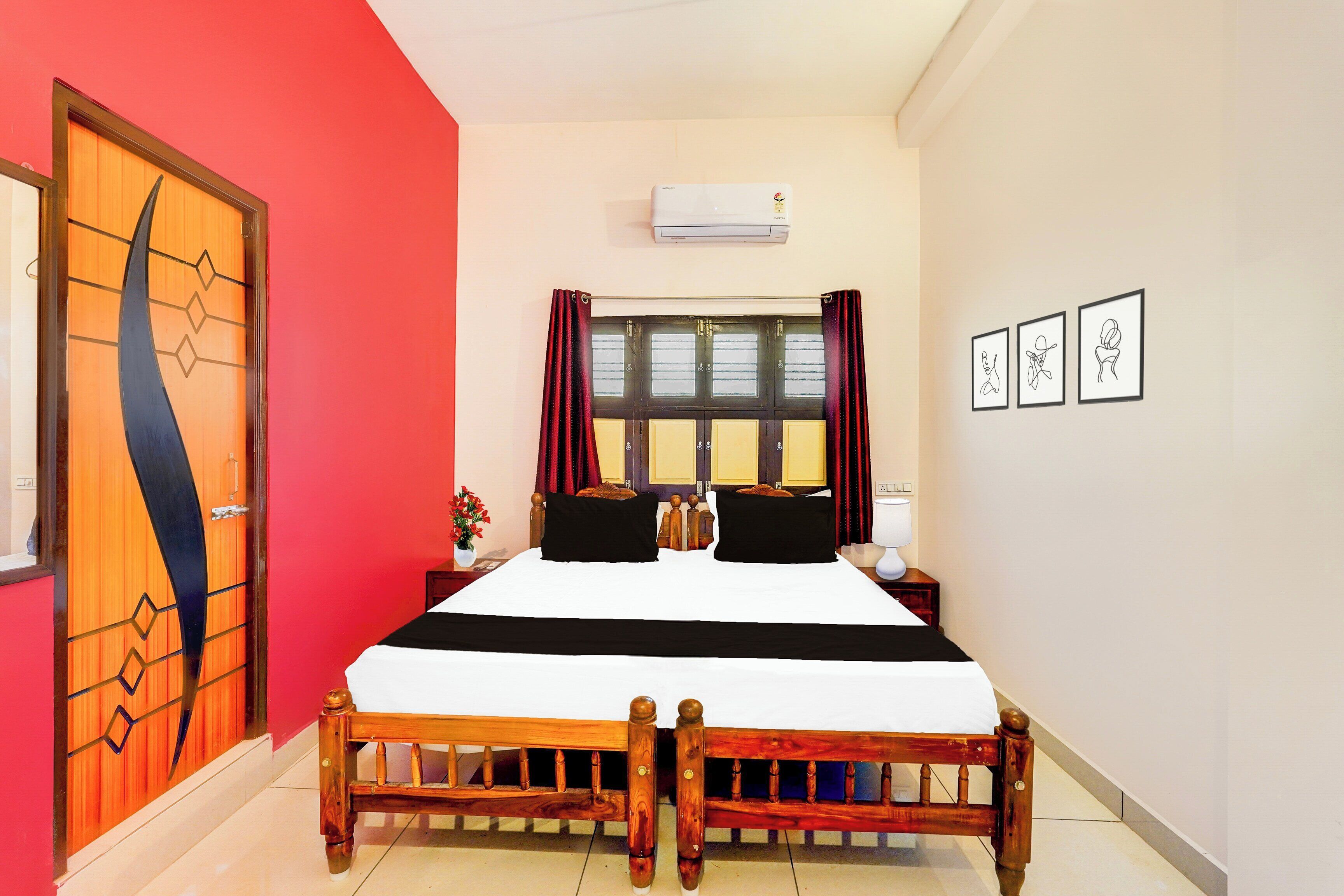 A bedroom with a bed, a window with curtains, a wall-mounted air conditioner, and framed artwork.