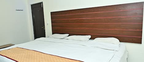 Une chambre à coucher avec un lit, une porte et une tête de lit.