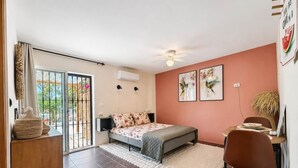 A bedroom with a bed, a desk, and a chair. There is a window with curtains, a ceiling fan, and a wall-mounted air conditioner. - Casa Carla Andalucia, Cabra, El Torcal (Almogía)