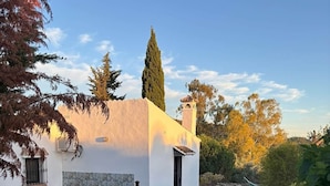 A white building with a chimney, surrounded by a garden with lavender plants. - Casa Carla Andalucia, Cabra, El Torcal (Almogía)