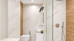 A modern bathroom with a toilet, sink, and shower. - Solea by Neuvel (Glyfada)