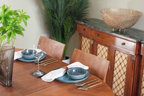Ein Esszimmer mit blauem Geschirr, einem Glas und Besteck, mit einer dekorativen Schüssel daneben.