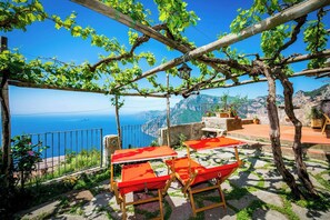 A terrace with a view of the sea, equipped with outdoor seating and potted plants. - 8th-century dwelling near Positano (Nocelle)