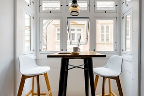 A room with a table and two chairs, a laptop, and a cup. - Birgu Room -Hammock Vibes Towns House (Tas-Sliema)