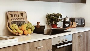 Een keuken met een aanrecht, een fruitmand, een bord met een WiFi-wachtwoord, een fornuis en een broodrooster.