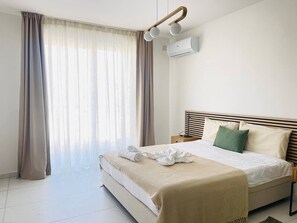 Ein Hotelzimmer mit einem Bett, Vorhängen, einer Klimaanlage und einem Nachttisch.