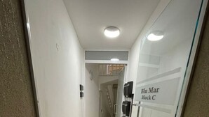 A hallway with a glass door labeled 'Blu Mar Block C' and a tiled floor. - Blu Mar Sea View Appartment 4 (San Pawl il-Baħar)
