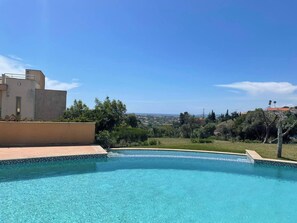 A swimming pool with clear blue water, surrounded by greenery and a view of a distant landscape. - Charming Holiday House With Stunning Views in Albufeira (Albufeira)