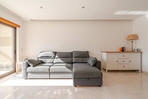 A modern living room with a grey sectional sofa, a white cabinet with drawers, and a floor lamp. - Charming Holiday House With Stunning Views in Albufeira (Albufeira)