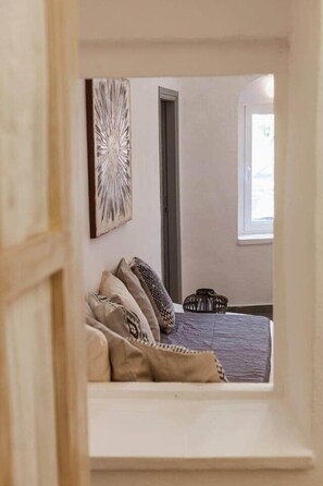 A bedroom with a bed, pillows, a wall-mounted artwork, a window, and a door. - Villa LuxL Family House (Mesaria)