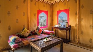 A room with a sofa, a table with a tray, and a window with a view.
