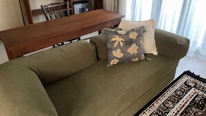 A living room with a sofa, a coffee table, and a dining table.