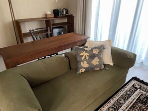 A living room with a sofa, a coffee table, and a dining table.