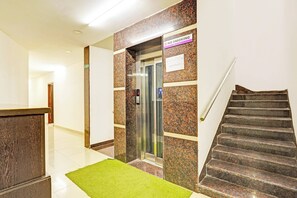 A reception area with a reception desk, a reception sign, a phone, and a staircase. - Collection O Vanamthopu Center Nellore (Nellore)