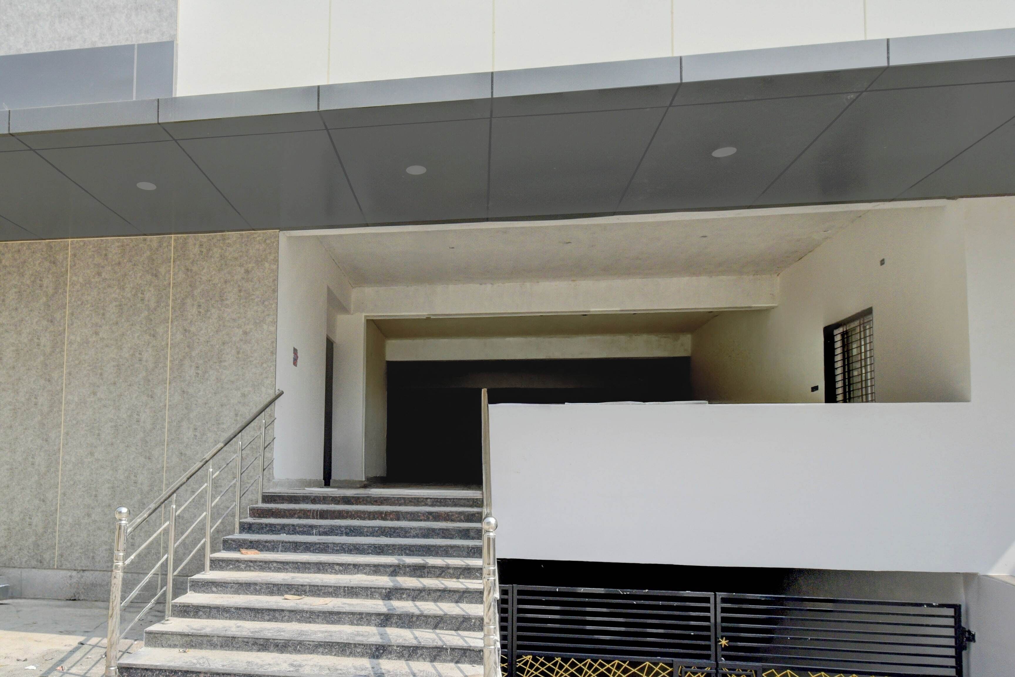 A building entrance with a staircase leading to a covered area.