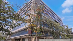 A modern building with a glass facade and a visible entrance. - Collection O Asalpha Metro Station (Mumbai)