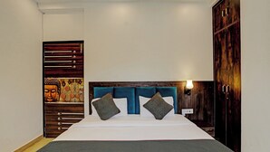 Une chambre à coucher comprenant un lit, une tête de lit, une armoire et un mur orné d’une image de Bouddha.