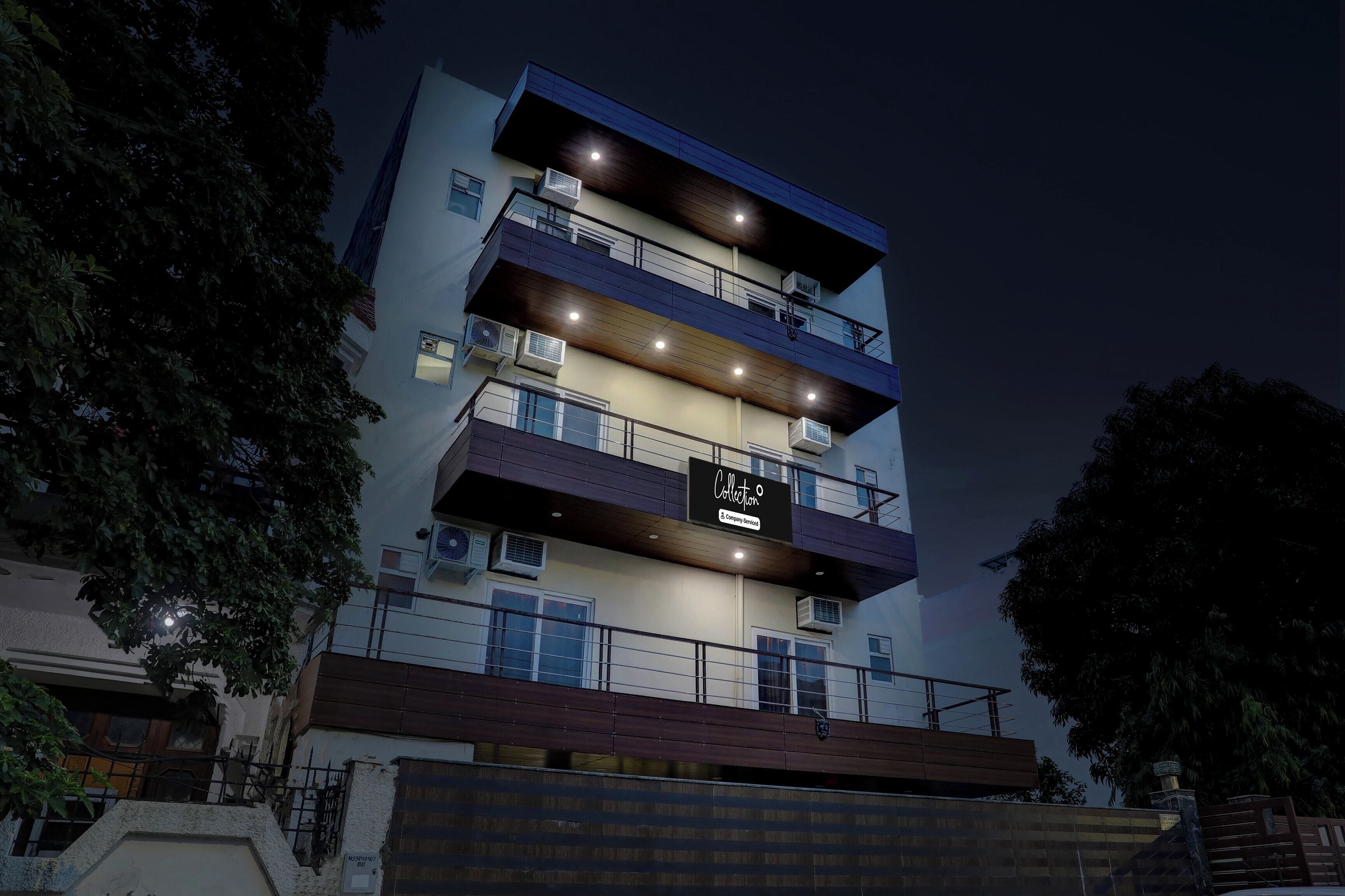 Un edificio de varios pisos con balcones, unidades de aire acondicionado y un letrero que indica que cuenta con servicio de empresa.