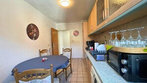 A compact kitchen with a dining table, chairs, a microwave, and a sink. - Spacious Apartment With Balcony (Boppard)