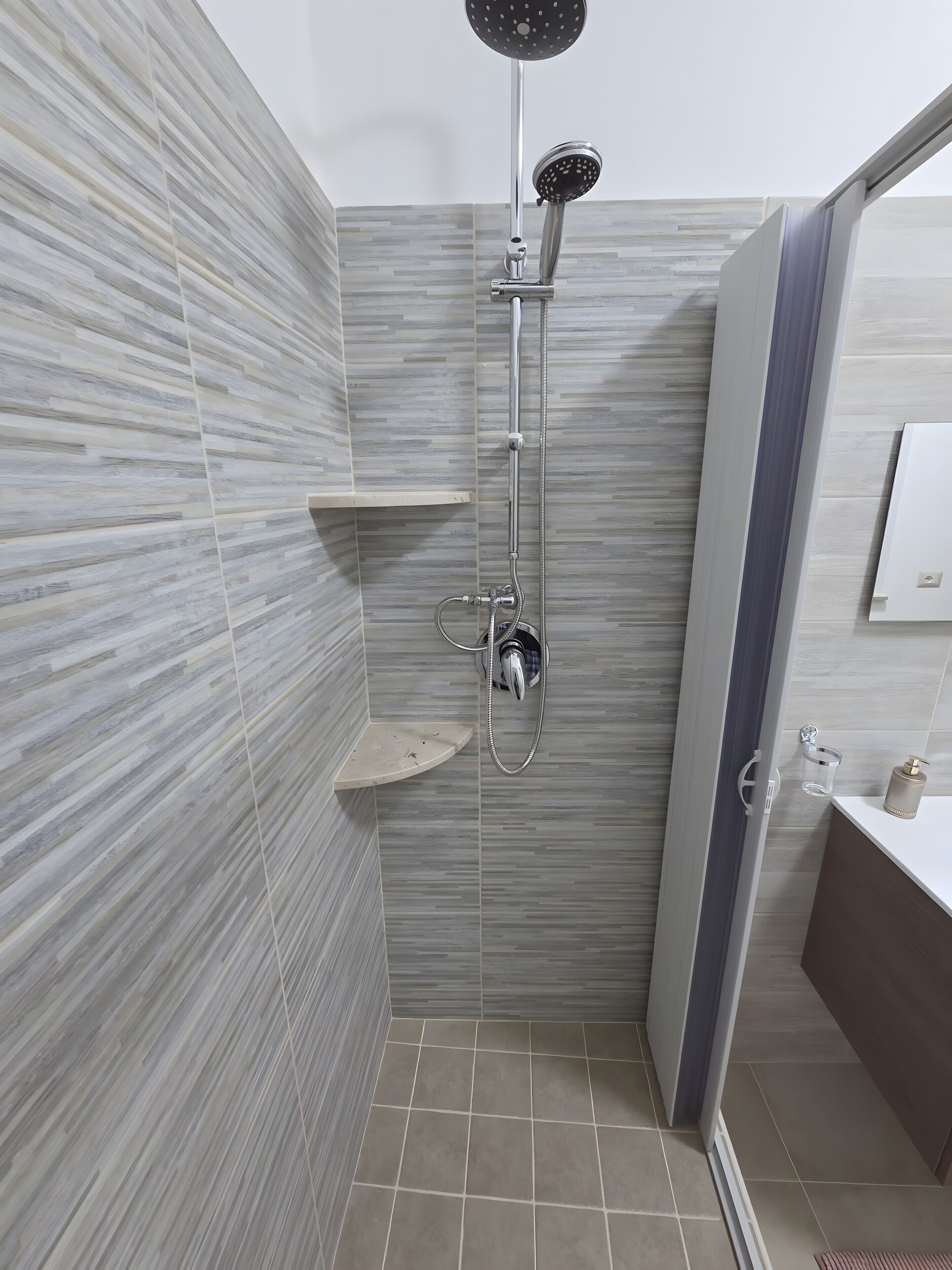 Un bagno moderno dotato di doccia, WC e lavandino.