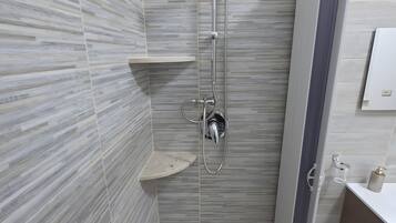 Un bagno moderno dotato di doccia, WC e lavandino.