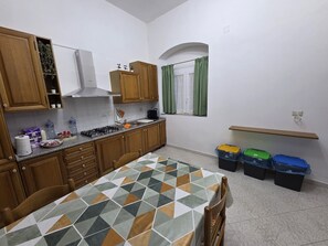 Una cucina con mobili in legno, piano cottura a gas e pavimento piastrellato.