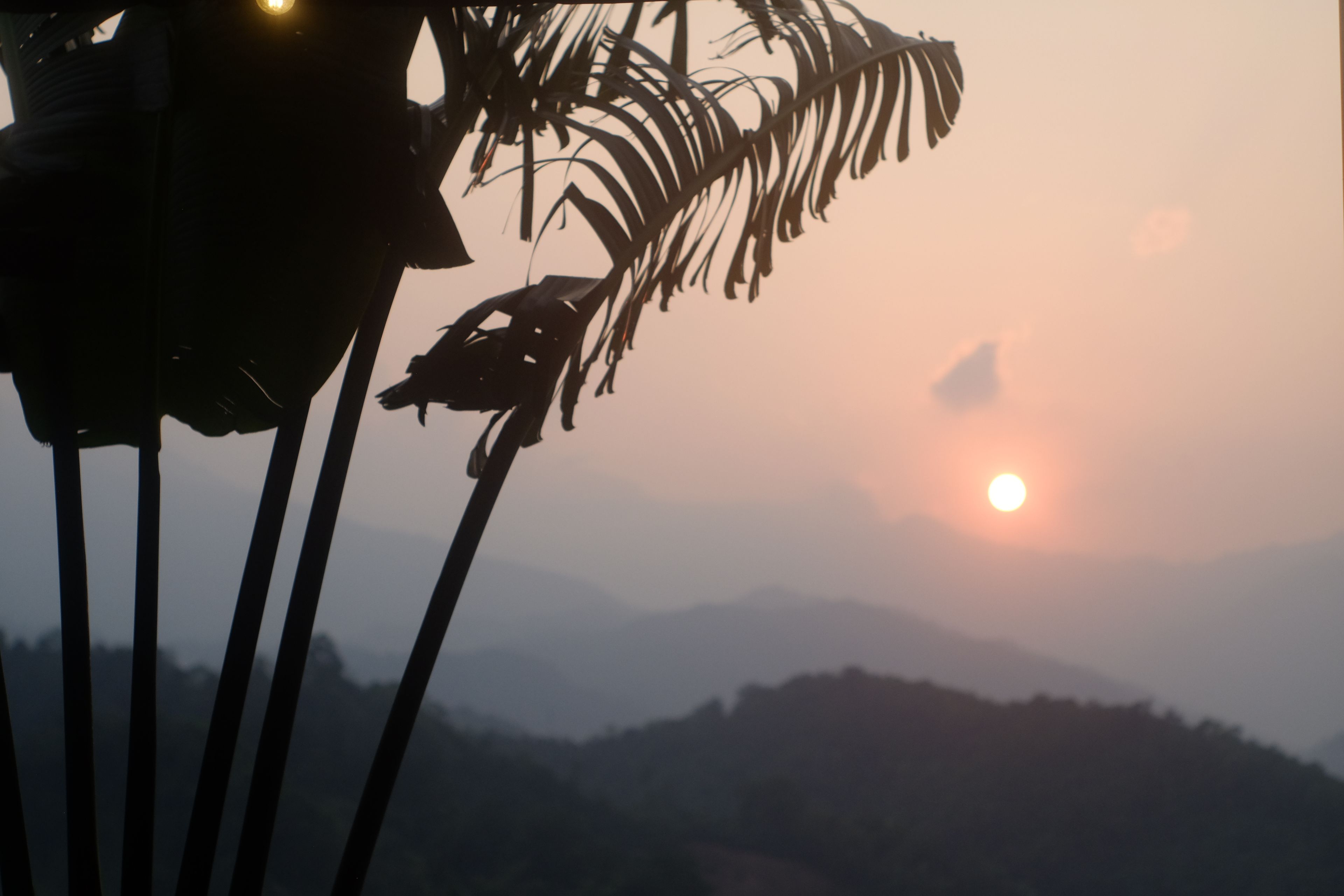 Un coucher de soleil avec des montagnes en arrière-plan.