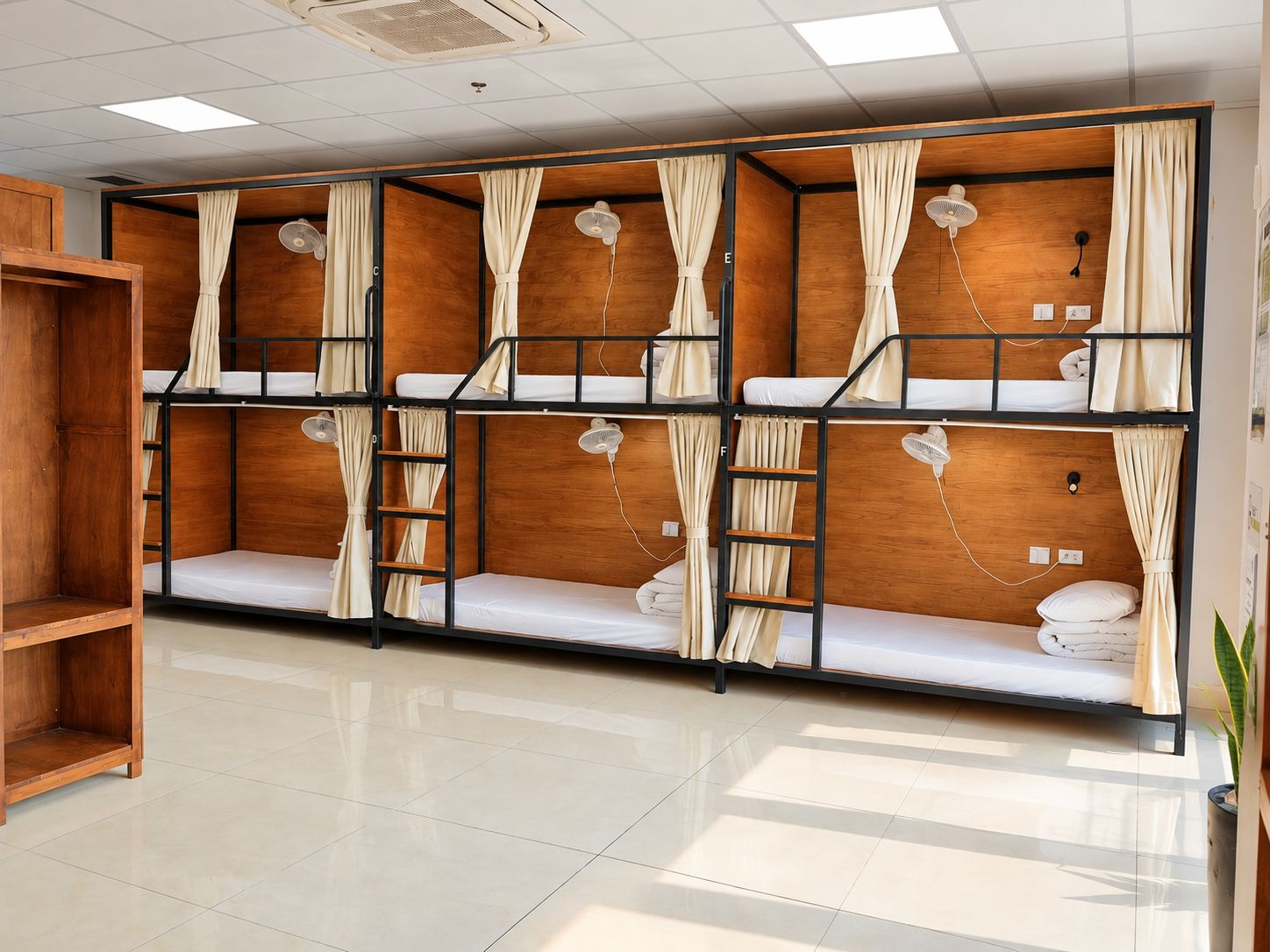 Un dormitorio con literas, cabeceros de madera y ventiladores de techo.