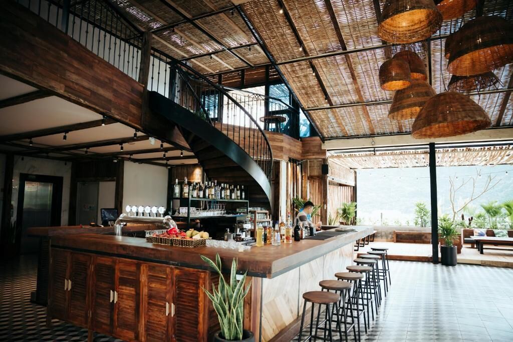 A bar area with a curved counter, stools, and a view of the outdoors.