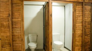 Puisella rungolla varustettu kylpyhuone, jossa on kaksi wc:tä.