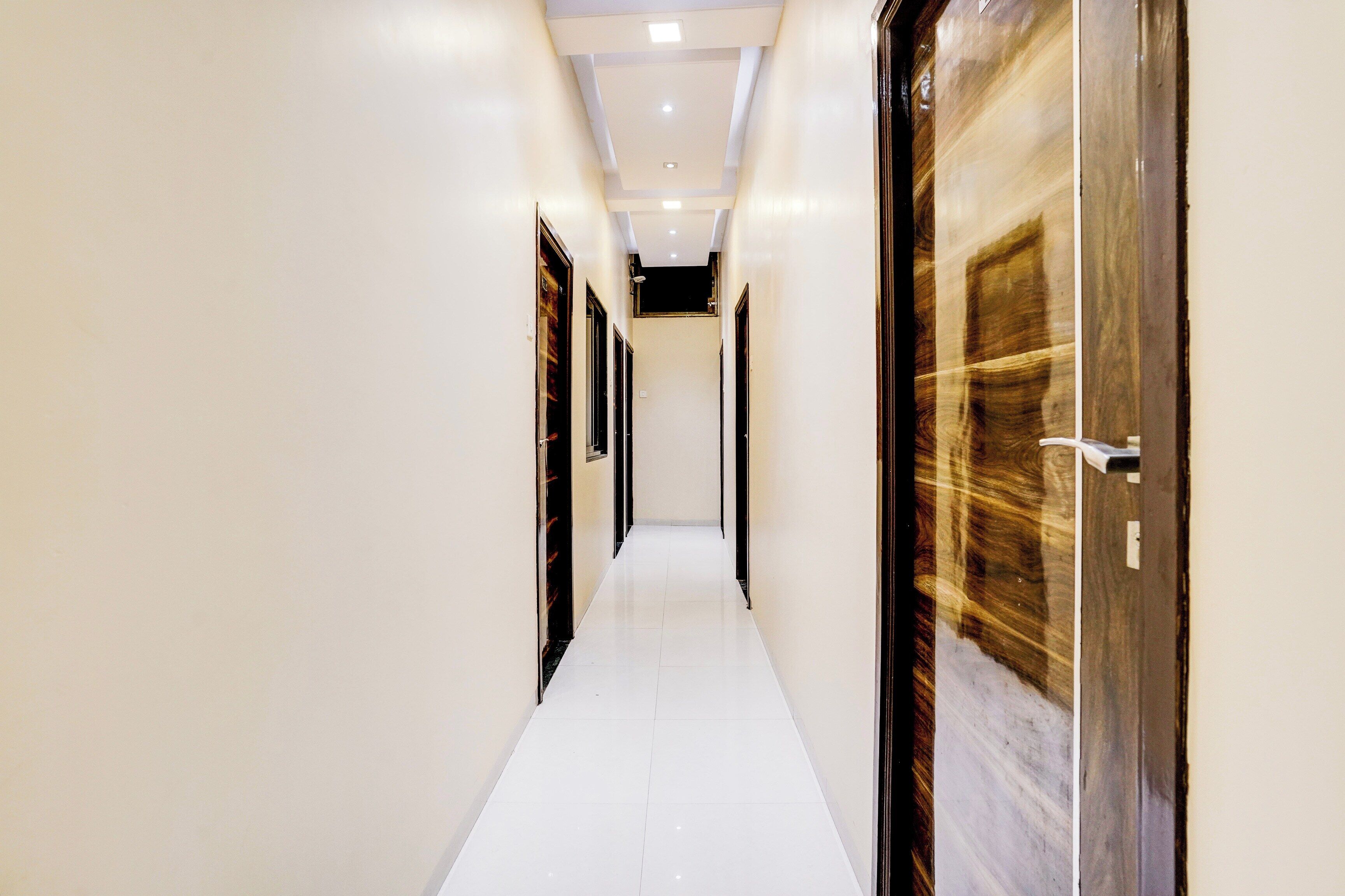 Un pasillo con puertas a ambos lados, que da acceso a habitaciones.