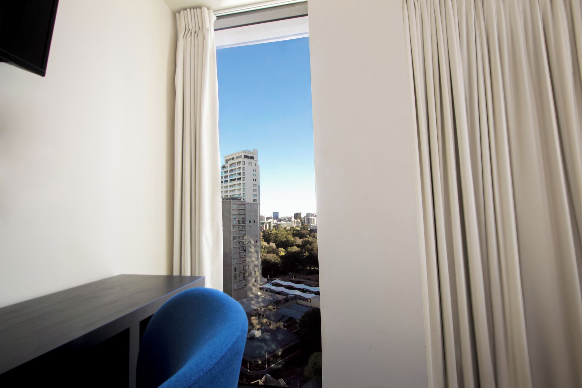 A room with a window, a desk, and a chair.