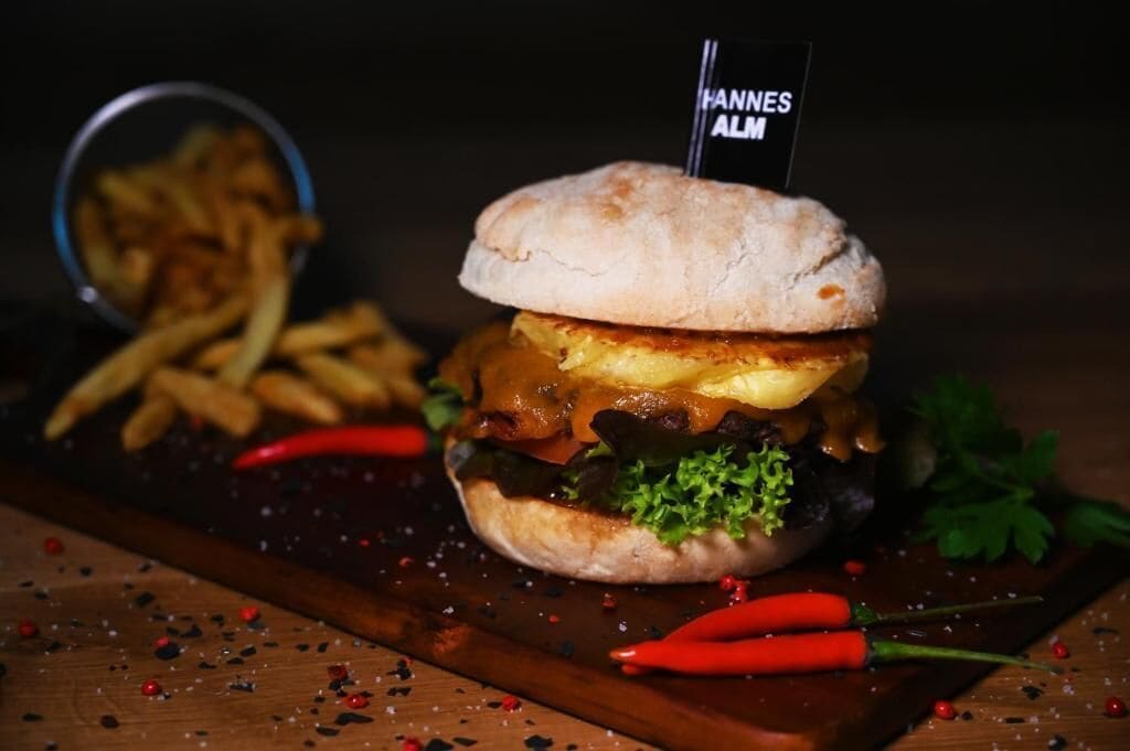 Ein Burger mit Pommes und einer kleinen Sauce.