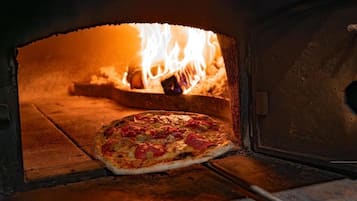 En pizza i en ugn med synliga lågor.