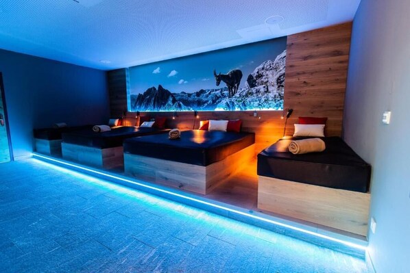 A modern room with a large wall mural, built-in seating, and ambient lighting.