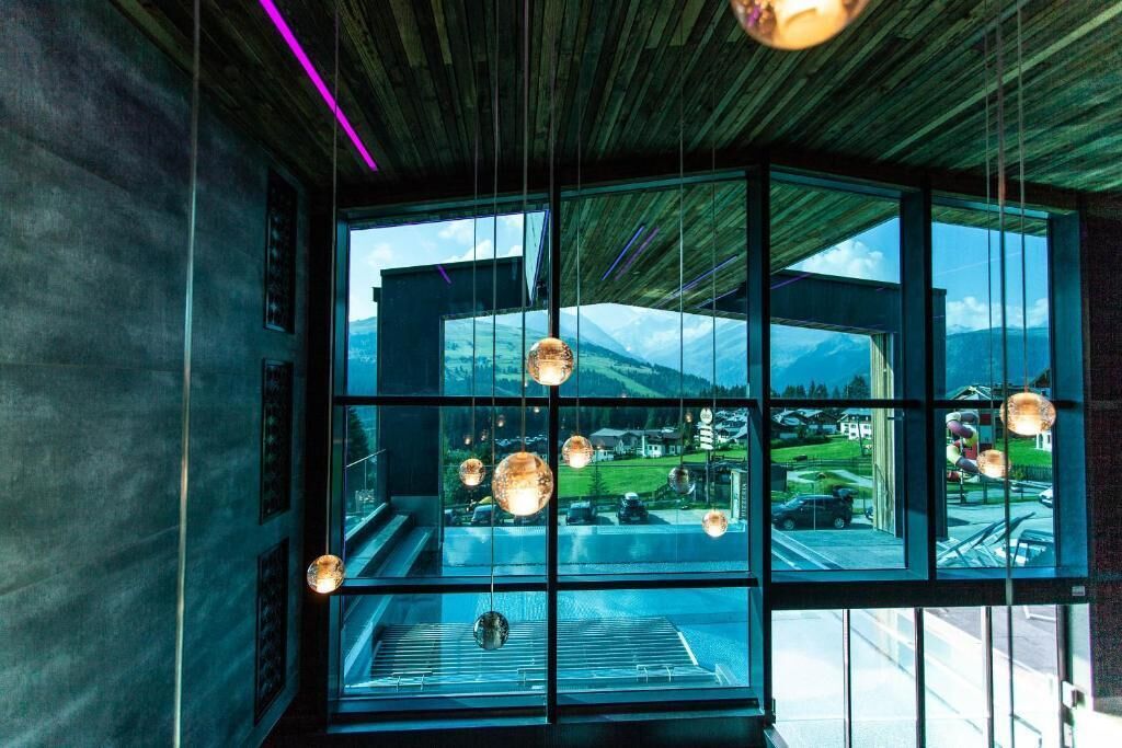 A modern interior with large windows offering a view of a mountainous landscape.