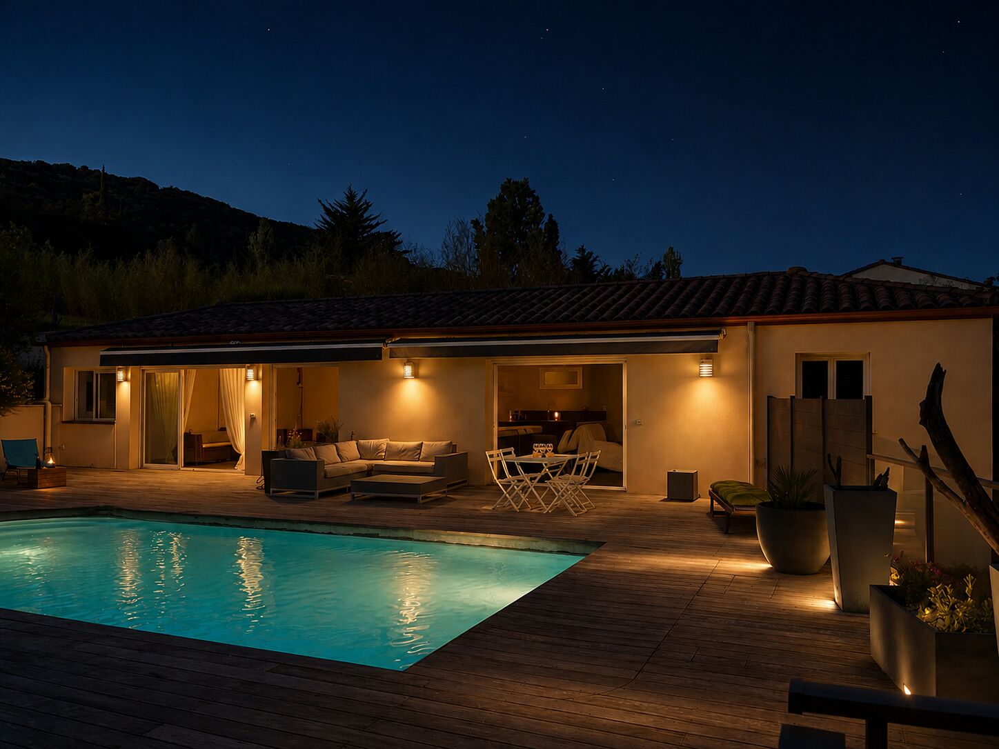 Una casa con piscina exterior, un patio techado con mobiliario y vistas del paisaje circundante.