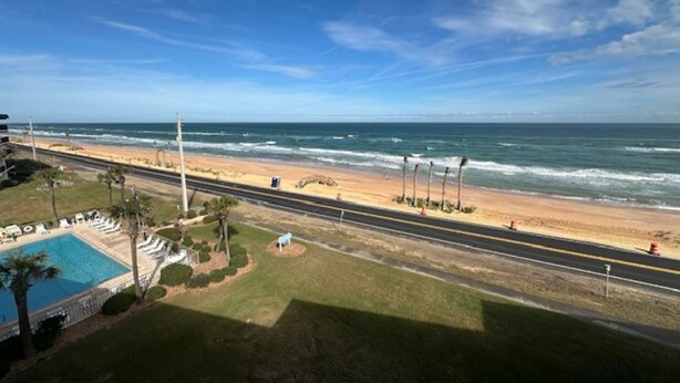 A coastal road with a beach, a swimming pool, and a clear sky. - 2-Bedroom 2-Bathroom 5th "TOP" Floor Condo in Stunning Ormond Beach with AC (Ormond Beach)