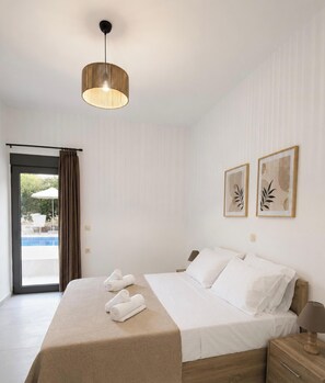 A hotel room with a bed, a bedside table, a lamp, a ceiling light, a window with curtains, and two framed pictures on the wall. - Villa Mark (Glossa)