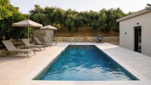 A rectangular swimming pool with a stone wall and a stone wall with a stone pattern. - Villa Mark (Glossa)
