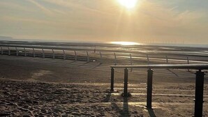 A beach with a metal railing and a clear sky. - Coastal Caravan at Lyons Robin Hood, Rhyl (Rhyl)