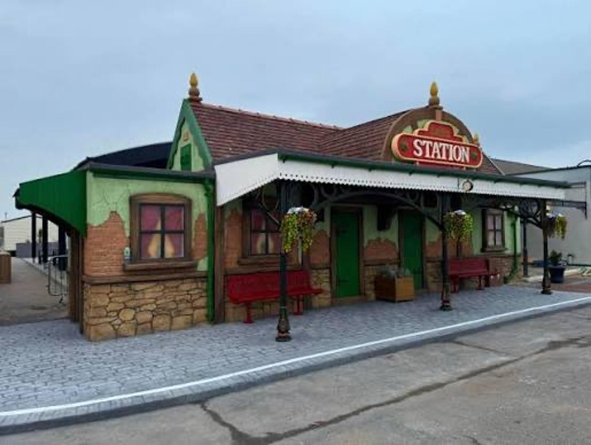 A building with a 'STATION' sign, a stone facade, and a tiled roof.