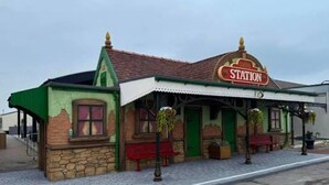 A building with a 'STATION' sign, a stone facade, and a tiled roof. - Coastal Caravan at Lyons Robin Hood, Rhyl (Rhyl)