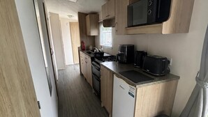 A compact kitchen with a microwave, toaster, and coffee maker. - Coastal Caravan at Lyons Robin Hood, Rhyl (Rhyl)