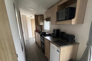 Eine kleine Küche mit Mikrowelle, Toaster und Kaffeemaschine.
