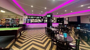 A billiards room with a pool table, multiple seating areas, and a bar with a neon-lit ceiling. - Coastal Caravan at Lyons Robin Hood, Rhyl (Rhyl)